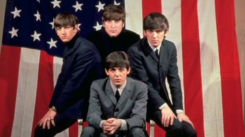 Movie still from “The Beatles: Eight Days a Week - The Touring Years” (2016), directed by Ron Howard – A group of men in suits posing for a picture; Wide shot, High angle