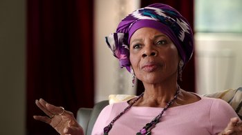 Movie still from “The Beatles: Eight Days a Week - The Touring Years” (2016), directed by Ron Howard – An older woman wearing a purple head scarf; Close Up shot, Low angle