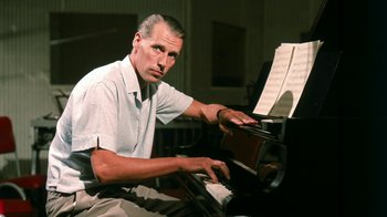 Movie still from “The Beatles: Eight Days a Week - The Touring Years” (2016), directed by Ron Howard – A man sitting in front of an open piano; Close Up shot, Low angle