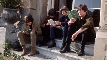 Movie still from “The Beatles: Eight Days a Week - The Touring Years” (2016), directed by Ron Howard – A group of people sitting on steps reading books; Medium shot, High angle
