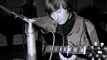 Movie still from “The Beatles: Eight Days a Week - The Touring Years” (2016), directed by Ron Howard – A man playing a guitar in front of a microphone; Close Up shot, Low angle