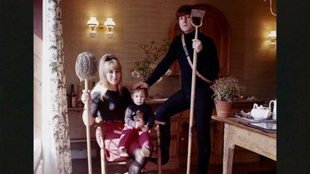 Movie still from “The Beatles: Eight Days a Week - The Touring Years” (2016), directed by Ron Howard – A woman and a man and a child are posing for a picture; Medium shot, High angle
