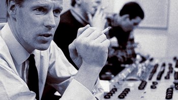 Movie still from “The Beatles: Eight Days a Week - The Touring Years” (2016), directed by Ron Howard – A man sitting at a table holding a cigarette in his hand; Close Up shot, Low angle