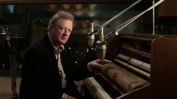 Movie still from “The Beatles: Eight Days a Week - The Touring Years” (2016), directed by Ron Howard – A man sitting at a piano in front of microphones; Close Up shot, High angle