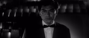 A black and white photo of a man in a tuxedo