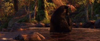 Movie still from “Brave” (2012), directed by Steve Purcell – A black bear sitting in the middle of a river; Wide shot, High angle