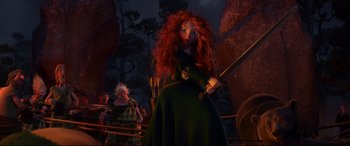 Movie still from “Brave” (2012), directed by Steve Purcell – A woman with red curly hair holding a sword; Wide shot, Low angle