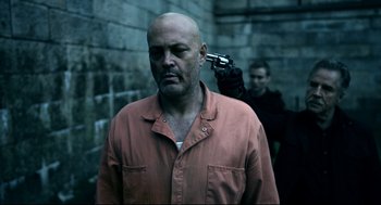 A man with a gun in his ear and another man holding a gun in his ear