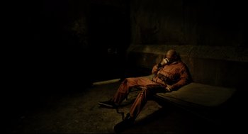 A man is sitting on the ground talking on a phone