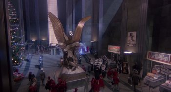 Movie still from “Brazil” (1985), directed by Terry Gilliam – A statue of an eagle is in the middle of a crowd of people; Extreme Wide shot, High angle