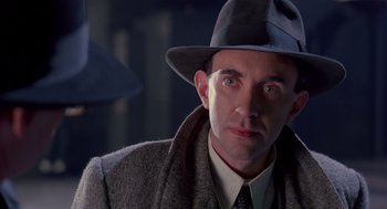 Movie still from “Brazil” (1985), directed by Terry Gilliam – A person wearing a hat and a coat; Close Up shot, Low angle