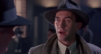 Movie still from “Brazil” (1985), directed by Terry Gilliam – A person wearing a suit and hat; Close Up shot, Low angle