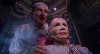 Movie still from “Brazil” (1985), directed by Terry Gilliam – A wax figure of an old woman being shaved by an old man; Close Up shot, Low angle
