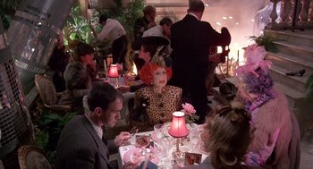 Movie still from “Brazil” (1985), directed by Terry Gilliam – A group of people sitting at a table with food; Wide shot, High angle