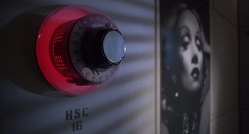 Movie still from “Brazil” (1985), directed by Terry Gilliam – A red and white timer; Extreme Close Up shot, Overhead angle