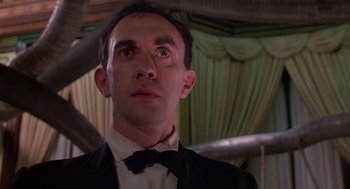 Movie still from “Brazil” (1985), directed by Terry Gilliam – A person wearing a suit and bow tie; Close Up shot, Low angle