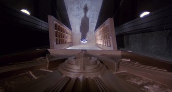 Movie still from “Brazil” (1985), directed by Terry Gilliam – A person standing on a platform in a building; Extreme Wide shot, Overhead angle