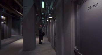 Movie still from “Brazil” (1985), directed by Terry Gilliam – A man standing in an empty hallway of an office building; Wide shot, High angle
