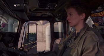 Movie still from “Brazil” (1985), directed by Terry Gilliam – A woman is sitting in the driver's seat of a vehicle; Close Up shot, Low angle