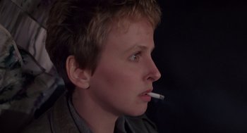 Movie still from “Brazil” (1985), directed by Terry Gilliam – A young man is smoking a cigarette while wearing a jacket; Close Up shot, Low angle