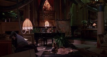 Movie still from “Brazil” (1985), directed by Terry Gilliam – A living room filled with furniture next to a fireplace; Wide shot, High angle