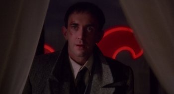 Movie still from “Brazil” (1985), directed by Terry Gilliam – A person wearing a suit and tie; Close Up shot, Low angle