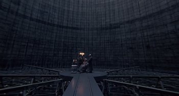 Movie still from “Brazil” (1985), directed by Terry Gilliam – A group of people standing in front of a large cooling tower; Extreme Wide shot, High angle