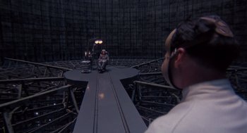 Movie still from “Brazil” (1985), directed by Terry Gilliam – A man sitting on top of a metal structure; Extreme Wide shot, High angle