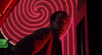 Movie still from “Brazil” (1985), directed by Terry Gilliam – A man standing in front of a spiral wall; Close Up shot, Low angle