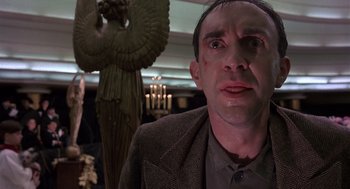 Movie still from “Brazil” (1985), directed by Terry Gilliam – A person wearing a suit and tie; Close Up shot, Low angle