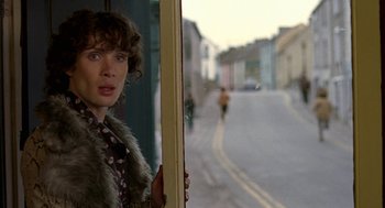 Movie still from “Breakfast on Pluto” (2005), directed by Neil Jordan – A man standing in front of a window looking out; Medium shot, Over the shoulder angle