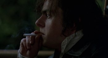 Movie still from “Breakfast on Pluto” (2005), directed by Neil Jordan – A young man smoking a cigarette while looking off into the distance; Close Up shot, Over the shoulder angle