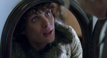 Movie still from “Breakfast on Pluto” (2005), directed by Neil Jordan – A person with a fur coat looking in a mirror; Close Up shot, Over the shoulder angle