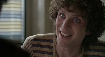 Movie still from “Breakfast on Pluto” (2005), directed by Neil Jordan – A person with a sweater on smiling; Close Up shot, Over the shoulder angle