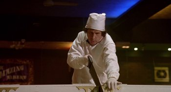 Movie still from “Breakfast on Pluto” (2005), directed by Neil Jordan – A man in a chef's hat is holding a large knife; Medium shot, Low angle