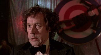 Movie still from “Breakfast on Pluto” (2005), directed by Neil Jordan – A person wearing a suit and tie; Close Up shot, Low angle