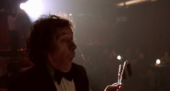 Movie still from “Breakfast on Pluto” (2005), directed by Neil Jordan – A man in a tuxedo holding a pair of toothbrushes; Close Up shot, Low angle