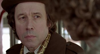 Movie still from “Breakfast on Pluto” (2005), directed by Neil Jordan – A person wearing a suit and tie; Close Up shot, Over the shoulder angle