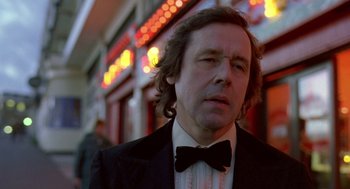 Movie still from “Breakfast on Pluto” (2005), directed by Neil Jordan – A person wearing a suit and bow tie; Close Up shot, Low angle