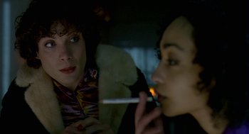 Movie still from “Breakfast on Pluto” (2005), directed by Neil Jordan – A woman smoking a cigarette while looking in the mirror; Close Up shot, Over the shoulder angle