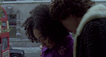 Movie still from “Breakfast on Pluto” (2005), directed by Neil Jordan – Two people standing next to each other on a sidewalk; Close Up shot, Over the shoulder angle