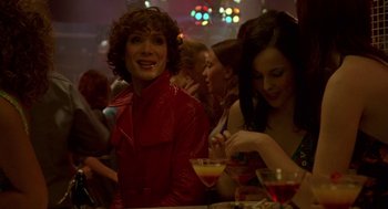 Movie still from “Breakfast on Pluto” (2005), directed by Neil Jordan – Two women are sitting at a table with drinks; Medium shot, Over the shoulder angle