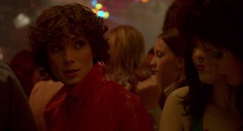 Movie still from “Breakfast on Pluto” (2005), directed by Neil Jordan – A woman in a red jacket and some other people; Close Up shot, Over the shoulder angle