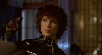 Movie still from “Breakfast on Pluto” (2005), directed by Neil Jordan – A woman in a black leather outfit with curly red hair; Close Up shot, Low angle