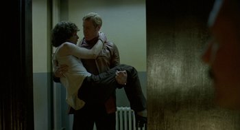 Movie still from “Breakfast on Pluto” (2005), directed by Neil Jordan – A man holding a woman upside down in a room; Medium shot, Low angle