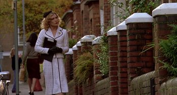 Movie still from “Breakfast on Pluto” (2005), directed by Neil Jordan – A woman walking down the street holding a book; Medium shot, Low angle