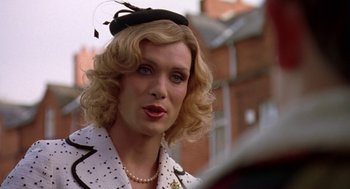Movie still from “Breakfast on Pluto” (2005), directed by Neil Jordan – A person wearing a hat and a jacket; Close Up shot, Over the shoulder angle