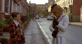 Movie still from “Breakfast on Pluto” (2005), directed by Neil Jordan – Two people standing on the side of the street talking to each other; Medium shot, Over the shoulder angle