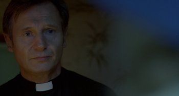 Movie still from “Breakfast on Pluto” (2005), directed by Neil Jordan – A man wearing a priest's collar and a black robe; Close Up shot, Low angle