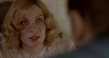 Movie still from “Breakfast on Pluto” (2005), directed by Neil Jordan – A person sitting in front of another person; Close Up shot, Over the shoulder angle